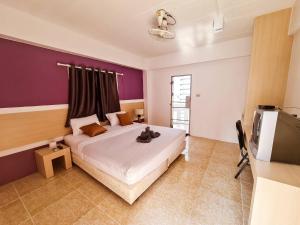 清迈Sleep CNX的一间卧室配有一张大床和紫色墙壁