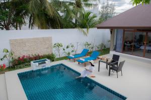 华欣Dhevan Dara Resort & Spa Hua Hin - Pool Villa的儿童跳入游泳池