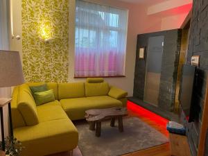 拉姆绍达赫斯坦Romantik Apartment mit SommerCard的客厅设有黄色沙发和电视