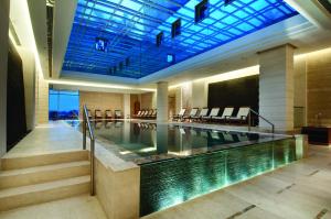 浦那Hyatt Regency Pune Hotel & Residences的一座带玻璃天花板的建筑中的游泳池
