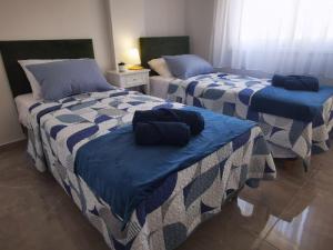 利马索尔Hawaii Holiday Apartment 41的一间设有两张蓝色和白色床单的房间