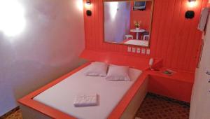 布卢梅瑙布卢梅瑙希斯纳汽车旅馆（仅限成人）的红色的浴室设有一张带镜子的长凳