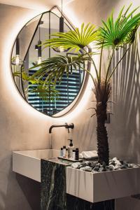 雅典Project 3 Urban Chic Hotel的一间带水槽、镜子和棕榈树的浴室