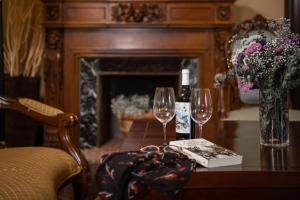 托罗埃利亚-德蒙特格里RVHotels Hotel Palau Lo Mirador的一张桌子,上面放着两杯酒和一瓶葡萄酒