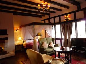 金马仑高原金马仑高原熏制房酒店&餐厅的一间卧室配有一张床、一张沙发和一张桌子