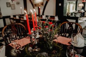金马仑高原金马仑高原熏制房酒店&餐厅的一张餐桌,上面有红色的蜡烛和鲜花