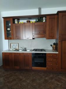 加拉托内Casa Elda的厨房配有木制橱柜和炉灶。