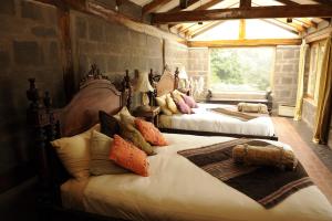 基多Hacienda Rumiloma by Rotamundos的一间卧室配有两张带枕头的床。