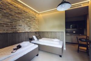 布达佩斯遗产之家公寓酒店的一间设有两张床和砖墙的房间