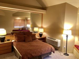 本德River Ridge 416B condo的一间卧室配有一张带两盏灯的床和风扇。