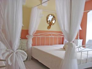 梅明根斯多辰法尔布公寓的一间卧室配有一张带白色窗帘和镜子的床