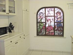 梅明根斯多辰法尔布公寓的厨房的墙上设有彩色玻璃窗