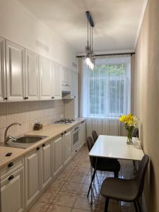 尼古拉耶夫2-комнатная квартира на Соборной的厨房配有白色橱柜和桌椅