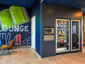 莫吉奥Ibis Budget Montpellier Aéroport Parc Des Expos的配有自动售货机和冰箱的客房