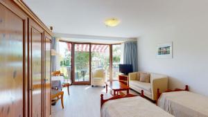 乌尔丁根-米赫尔霍芬Hotel Seepark Appartements的一间带两张床的卧室和一间客厅