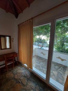 KoumeikaBeautiful house wiht sea view in Samos Island的带推拉玻璃门和窗户的房间