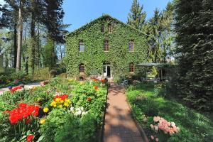 丹加斯特Pension Altes Posthaus的常春藤覆盖着鲜花花园的房子