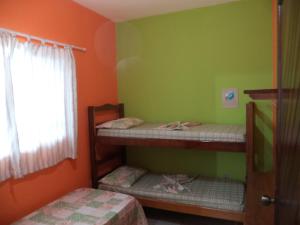 乌巴图巴Pisco Chalés的两张双层床,位于带绿色和橙色墙壁的客房