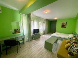金沙Villa Jackie的绿色卧室设有床和电视