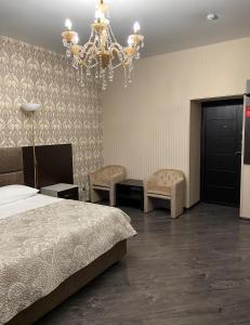 Achinskотель VICTORIA CITY的一间卧室配有一张床和一个吊灯
