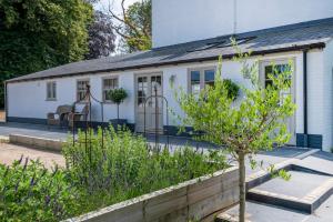 Ormesby Saint MichaelThe Shepherds Huts at Ormesby Manor的白色的房子,有门廊和树