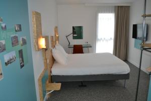 Pacégreet Hotel Rennes Pace的卧室配有白色的床和灯