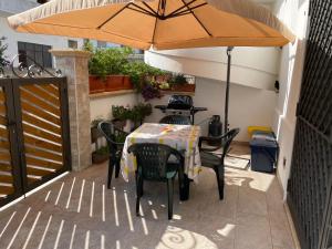 拉卡莱Appartamento low cost nel cuore del Salento的庭院内桌椅和遮阳伞