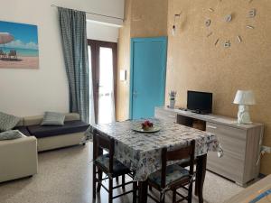 拉卡莱Appartamento low cost nel cuore del Salento的客厅配有桌子和沙发