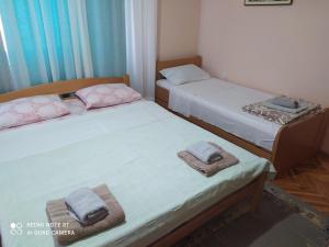 哥鲁拜克Apartment & Rooms Aleksandar的小客房内的两张床和毛巾