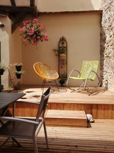 凯泽贝尔Gîte Le Patio的木甲板上配有两把椅子和一张桌子