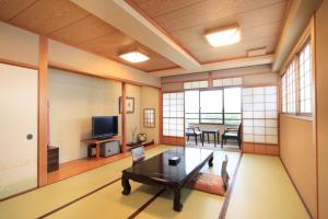 高山火沙卡库酒店的客厅配有桌子和电视