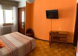 卢戈西班牙酒店的一间卧室配有一张床、一张桌子和一台电视