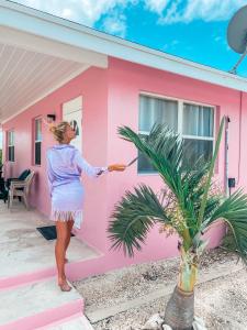 Hartswell热带风光景观别墅的女人站在粉红色房子外面