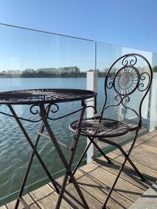 伊普尔Vijverhuis的坐在靠近水面的码头上的桌子和椅子