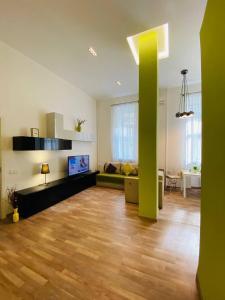 基辅基辅中心纯真家园公寓的一间客厅,在房间内有一个绿柱子