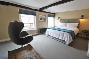 戴德姆The Marlborough Dedham的一间卧室配有一张床和一把椅子