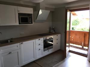 滨湖采尔Appartement Kitzsteinhorn的厨房配有白色橱柜和微波炉