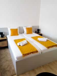 卡尔洛瓦茨Evita Studio Apartment的一张白色大床,上面有黄色枕头