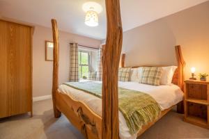 莱伯恩West Shaw Cote Cottage的一间卧室配有一张木制四柱床