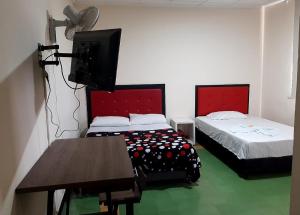 OcañaHotel Majestic的客房设有两张床、一台电视和一张桌子。