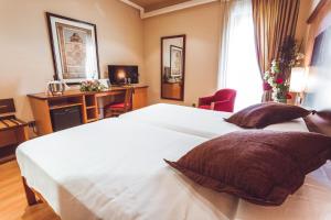 萨拉曼卡Hotel Bardo Recoletos Coco的一间卧室配有两张白色的床和一张书桌