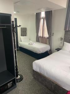 诺丁汉诺丁汉特里维尔斯摄政酒店的酒店客房设有两张床和电视。