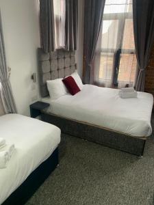 诺丁汉诺丁汉特里维尔斯摄政酒店的配有窗户的酒店客房内的两张床