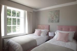 约克10 Bootham House - luxury city centre apartment with free parking for one car的带2扇窗户的客房内的2张床