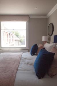 约克10 Bootham House - luxury city centre apartment with free parking for one car的一间卧室配有一张带蓝色枕头的大床和窗户。