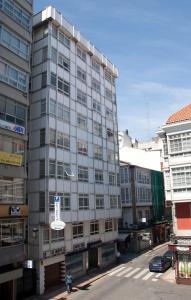 拉科鲁尼亚拉普威采娜旅馆的一座高大的灰色建筑,前面有标志