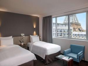 巴黎铂尔曼度假巴黎埃菲尔铁塔酒店的酒店客房带两张床,还有埃菲尔铁塔。