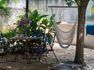 梅里达Casa "La 44"的花园内提供桌椅和吊床。