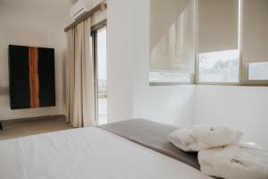 帕尔加elia boutique hotel的一间卧室配有一张带白色床单的床和一扇窗户。
