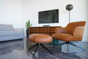 杜布罗夫尼克New&Luxury Apartment with an Outstanding View - Bombii Blue的客厅配有两把椅子和电视